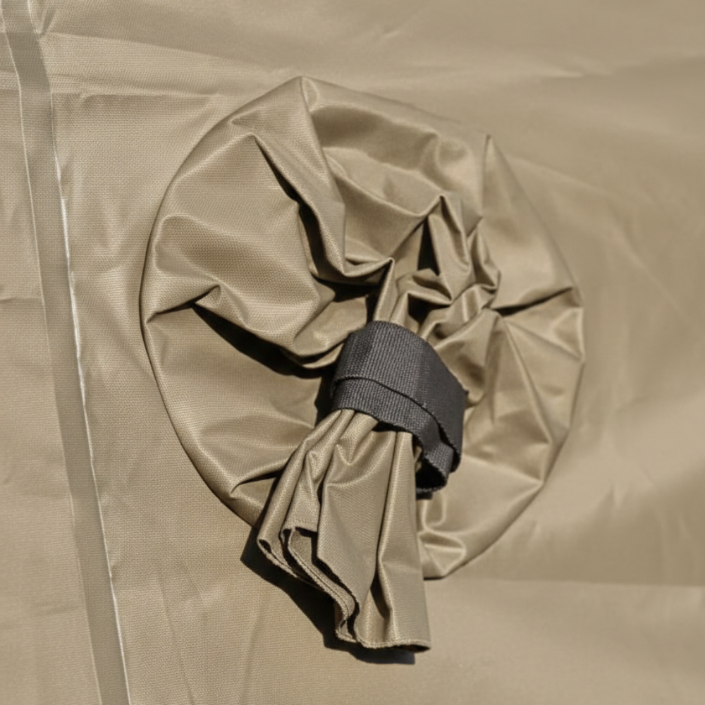 Heizungsdurchführung für ein aufblasbares Schnelleinsatzzelt. Detailaufnahme der sandfarbenen Schlauchdurchführung mit schwarzem Fixiergurt zum Anschluss von externen Heiz- oder Klimageräten an Sanitätszelten und Notunterkünften.